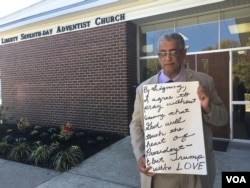 Rocky Twyman solicits signatures on a card that reads: "By signing, I agree to pray without ceasing that God will touch the heart of President-elect Trump with LOVE," at Liberty Seventh-day Adventist Church in Baltimore, Maryland. (A. Arabasadi/VOA)