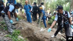 Polisi Thailand mengukur kuburan-kuburan dangkal di provinsi Songkhla, Thailand selatan (2/5). (AP/Sumeth Panpetch)