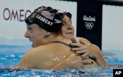 United States' Katie Ledecky, left, is congratulated by United States' Leah Smith after winning the gold medal in the women's 400-meter freestyle setting a new world record during the swimming competitions at the 2016 Summer Olympics, Sunday, Aug. 7, 2016