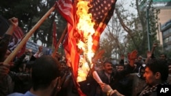 Hardline Iranian demonstrators burn representations of the U.S. flag during a gathering in front of the former U.S. Embassy in Tehran, May 9, 2018, reacting to President Donald Trump's decision to pull out of the nuclear deal.