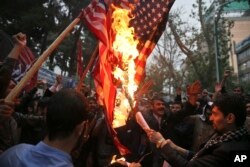 Hardline Iranian demonstrators burn representations of the U.S. flag during a gathering in front of the former U.S. Embassy in Tehran, Iran, May 9, 2018, reacting to President Donald Trump's decision to pull out of the nuclear deal.