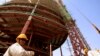 FILE - A building rises behind a Chinese engineer on the skyline of Khartoum, the capital of Sudan, in 2009. 