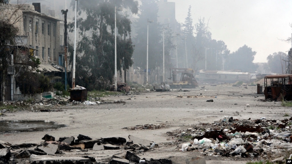 En esta foto divulgada por la agencia oficial de noticias siria SANA se ve una calle dañada por enfrentamientos fuerzas del gobierno sirio y rebeldes cerca de la plaza Abbassiyin, en el este de Damasco, Siria, el lunes, 20 de marzo, de 2017.