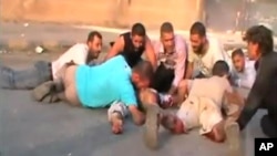 An image grab from a video uploaded on YouTube on July 31, 2011 shows Syrians seeking cover from shooting allegedly by security forces in the city of Hama.