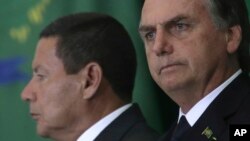 While Brazil's President Jair Bolsonaro was attending the World Economic Forum, Jan. 23, 2019, Vice President Hamilton Mourao, left, signed the decree expanding exceptions within the 2011 transparency law.