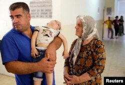 FILE - Iraqi Christians, who fled violence brought by Islamic State militants in the village of Qaraqosh, seek refuge inside a church building in Irbil, north of Baghdad, Aug. 11, 2014.