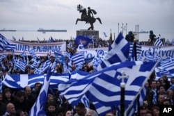 FILE - Greek protesters wave flags and banners during a rally against the use of the term "Macedonia" for the northern neighboring country's name, at the northern Greek city of Thessaloniki, Jan. 21, 2018.