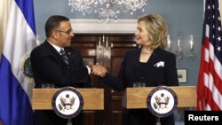 La secretaria de Estado Hillary Clinton da la mano al presidente de El Salvador, Mauricio Funes. El Salvador es uno de los beneficiados por la MCC.