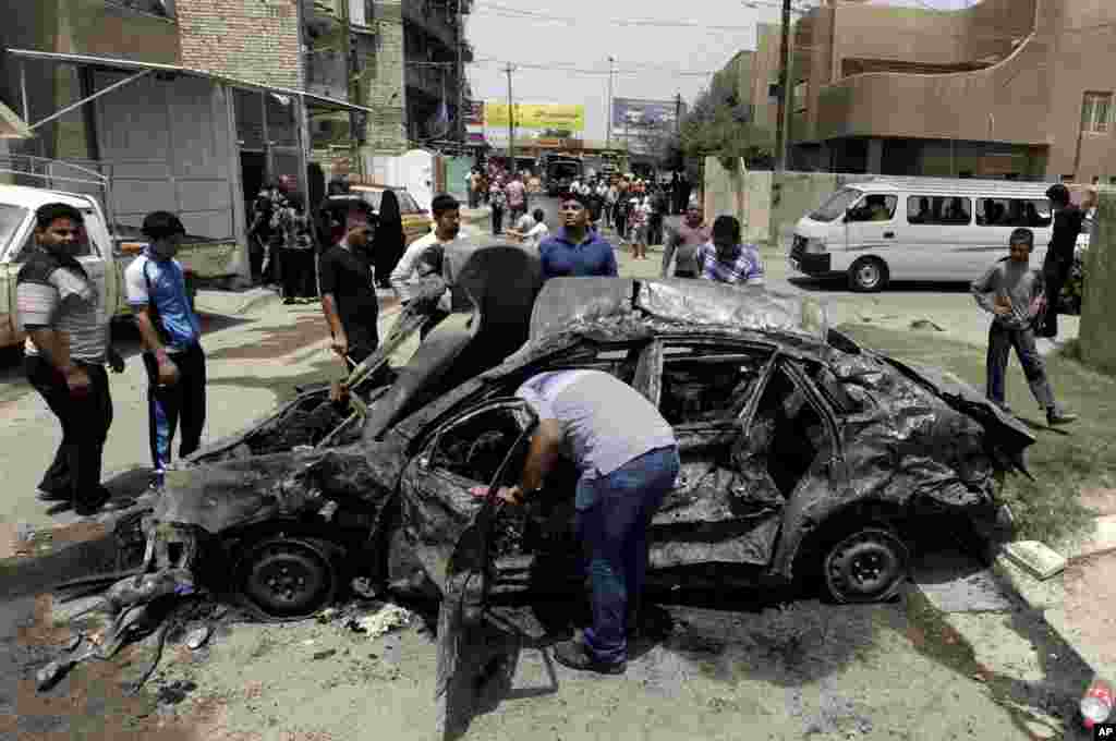 People look at damage from a car bomb, Baghdad, May 30, 2013. 