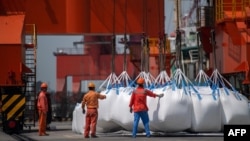 지난 7일 중국 동부 장쑤성 장자강 항에서 인부들이 화학제품 포대를 하역하고 있다.