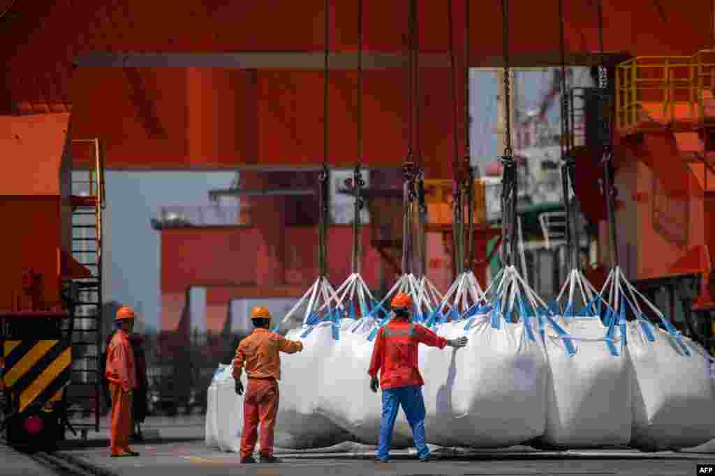2018年8月7日，工人在中国江苏省张家港的一个港口卸下袋装的化学品。