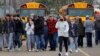 Orang tua dengan anak-anak mereka pergi meninggalkan tempat parkir Meijer setelah insiden penembakan di Oxford High School di Oxford, Michigan, AS, 30 November 2021. (Foto: Eric Seals-USA TODAY NETWORK via REUTERS)