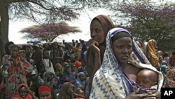 Somalis displaced by drought wait to receive food in their makeshift camp in Mogadishu, July 23, 2011
