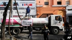 Empleados de los Sistemas de Agua de la Ciudad de México y policías de tránsito realizan labores relacionadas con la distribución de agua en barrios de la capital mexicana. (Archivo)