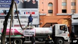Empleados de los Sistemas de Agua de la Ciudad de México y policías de tránsito cerca a un tanque de agua que está siendo llenado en Ciudad de México el tres de noviembre del 2018. 