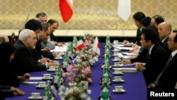 Iran's Foreign Minister Mohammad Javad Zarif (2nd L) speaks with his Japanese counterpart Fumio Kishida (2nd R) at a meeting in Tokyo, March 5, 2014, as Japan paid Iran $450 million owed for oil imports.