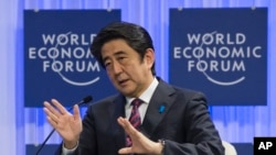 Japanese Prime Minister Shinzo Abe gestures as he speaks at the World Economic Forum in Davos, Switzerland, Wednesday, Jan. 22, 2014.