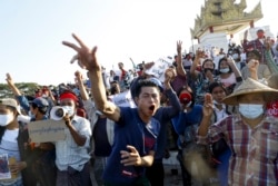 Para pengunjuk rasa menunjukkan simbol perlawanan tiga jari terhadap kudeta militer dan meneriakkan slogan-slogan yang menyerukan pembebasan pemimpin Myanmar yang ditahan Aung San Suu Kyi selama protes di Mandalay, Myanmar pada 10 Februari 2021. (Foto: AP)