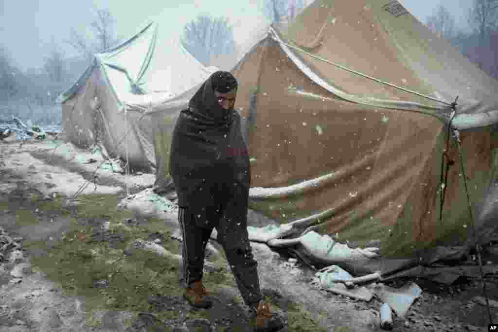 A migrant walks during snowfall at the Vucjak refugee camp outside Bihac, northwestern Bosnia.