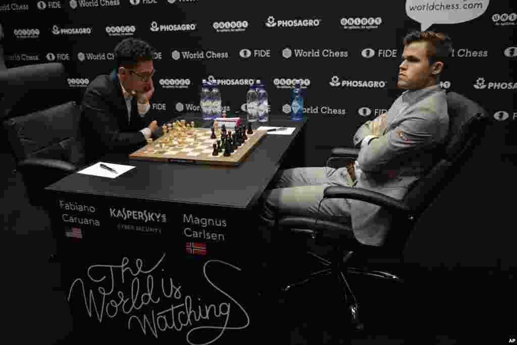 Reigning chess world champion Magnus Carlsen, right, from Norway, plays Italian-American challenger Fabiano Caruana in the first five minutes of round three of their World Chess Championship Match in London.