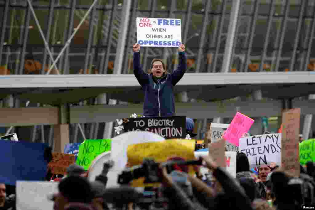 A man yells during a protest against U.S. President Donald Trump&#39;s travel ban, outside Terminal 4 at John F. Kennedy International Airport in Queens, New York, Jan. 28, 2017.