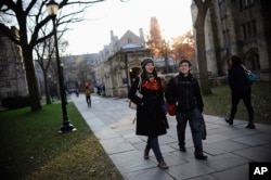 FILE - Yale University student Yupei Guo, left, walks with friend Joseph Lachman on the school's campus in New Haven, Conn., In Nov. 20, 2014.