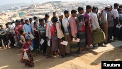 FILE - Rohingya refugees stand in a queue to collect aid supplies in Kutupalong refugee camp in Cox's Bazar, Bangladesh, Jan. 21, 2018.