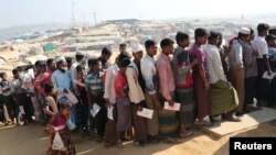 Rohingya refugees stand in a queue to collect aid supplies in Kutupalong refugee camp in Cox's Bazar, Bangladesh, Jan. 21, 2018.