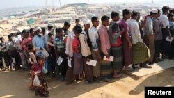 Rohingya refugees stand in a queue to collect aid supplies in Kutupalong refugee camp in Cox's Bazar, Bangladesh, Jan. 21, 2018.