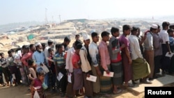 Para pengungsi Rohingya antre untuk mengambil bantuan di kamp pengungsi Kutupalong, di Cox's Bazar, Bangladesh, 21 Januari 2018.