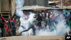 Supporters of Kenyan opposition leader and presidential candidate Raila Odinga throw back a tear gas canister at Kenyan security forces in the Mathare slum of Nairobi, Aug. 9, 2017.