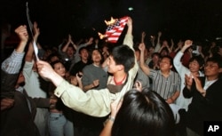 1999年5月8日，在北约误炸中国驻南斯拉夫大使馆之后，北京学生在美国使馆外面焚烧美国国旗