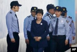 FILE - Former South Korean President Park Geun-hye, center, arrives at a court in Seoul, South Korea, May 23, 2017.