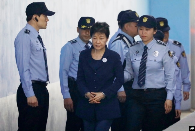 FILE - Former South Korean President Park Geun-hye, center, arrives at a court in Seoul, South Korea, May 23, 2017.