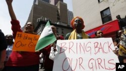 Activist Dr. Delois Blakely, right, is joined by others while chanting during a rally in front of the Nigerian consulate, May 10, 2014, in New York. 