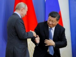 Presiden China Xi Jinping, dan Presiden Rusia Vladimir Putin berjabat tangan selama upacara pemberian gelar kepada Xi Jinping dari Universitas Negeri St. Petersburg di Forum Ekonomi Internasional St. Petersburg. (Foto: Reuters)