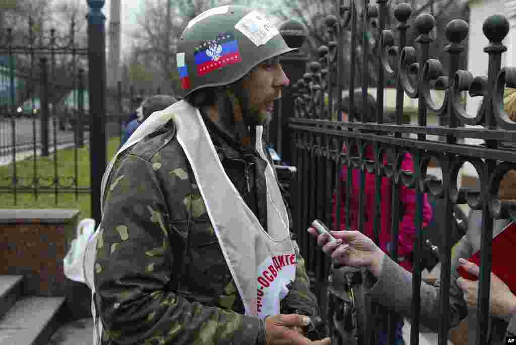 A pro-Russian protester whose helmet reads "Donetsk Republic," pickets a building where Ukraine's Prime Minister Arseniy Yatsenyuk was meeting with regional leaders from eastern Ukraine, in Donetsk, April 11, 2014. 