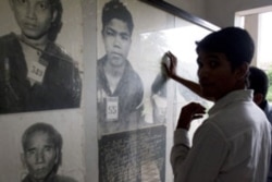FILE -Cambodian men view portraits of Khmer Rouge's victims at Tuol Sleng genocide museum in Phnom Penh, Cambodia. (AP Photo)