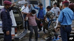 The body of a victim is removed from the site of an explosion in Kathmandu, Nepal, May 26, 2019. 