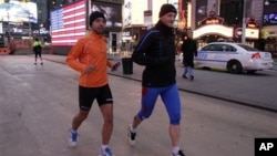 Ricardo Burnia (kiri) dan Simon Capaccioni dari Italia tengah melatih diri untuk persiapan mengikuti lomba marathon di Times Square, New York (2/11). Lomba marathon tahunan yang semula direncanakan akan digelar hari Minggu, dibatalkan oleh walikota Bloomberg, setelah mendapat tekanan warga korban badai Sandy, yang memprotes keputusan walikota sebelumnya untuk terus menggelar acara ini.