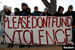 FILE - Opponents of the Dakota Access oil pipeline rally outside the Bank of North Dakota in Bismarck, Jan. 31, 2017.