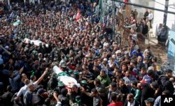 FILE - Palestinian mourners carry the bodies of two of the seven Hamas militants who were killed in an Israeli raid late Sunday, during their funerals in Khan Younis, southern Gaza Strip, Nov. 12, 2018.