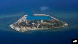 FILE - The Vietnamese-claimed Southwest Cay island in the Spratly island group is seen from a Philippine Air Force C-130 transport plane during the visit to the Philippine-claimed Thitu Island by Defense Secretary Delfin Lorenzana, Armed Forces Chief Gen.