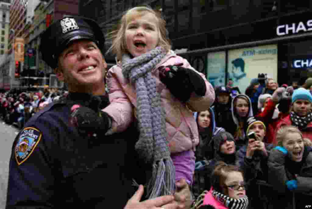 New York City police officer Wally Melvin holds his 5-year-old daughter Carlee as they watch Santa Claus pass by during the Macy's Thanksgiving Day Parade in New York Thursday, Nov. 25, 2010. (AP Photo/Craig Ruttle)
