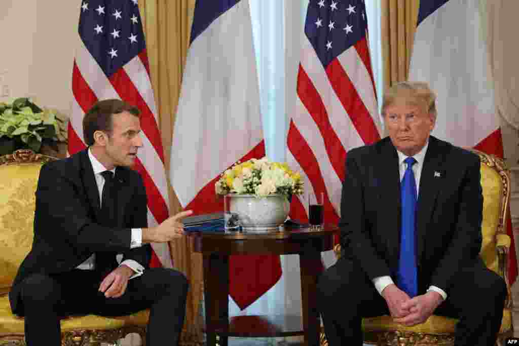 U.S. President Donald Trump (R) listens when his French counterpart Emmanuel Macron speaks during their meeting at Winfield House, London.