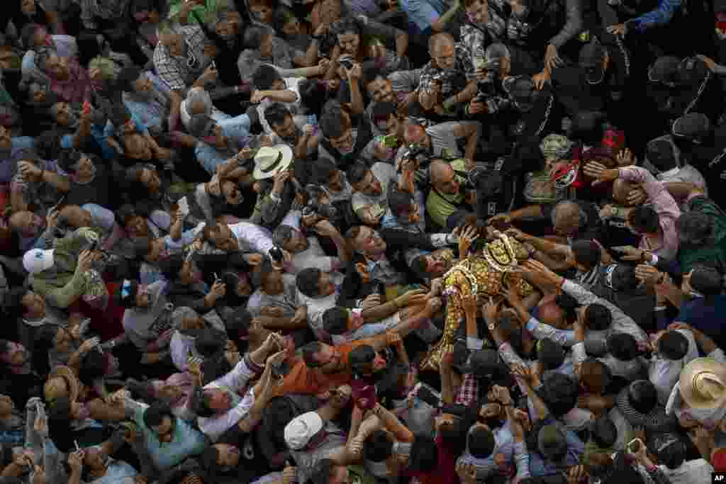 French bullfighter Sebastian Castella is carried and greeted by supporters as he leaves the bullring after an extraordinary performance during a bullfight of the San Isidro fair in Madrid, Spain, May 27, 2015.