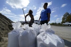 Stephanie Verrett, Louisiana eyaletinin Houma kasabasındaki evini su baskınından korumak için kum torbaları hazırlıyor.