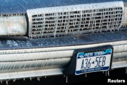 Icicles form on a car in front of a building where the New York Fire Department was fighting a fire in low temperatures, Jan. 7, 2014.