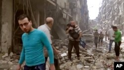ຜູ້ຊາຍຄົນນຶ່ງອູ້ມເດັກນ້ອຍອອກໄປ ຫຼັງຈາກການໂຈມຕີ ທາງອາກາດ ໃສ່ໂຮງໝໍເດັກ ທີ່ເມືອງ Aleppo ປະເທດຊີເຣຍ. (28 ເມສາ 2016)​