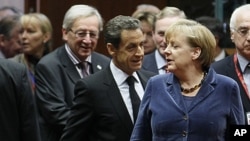 Luxembourg's Prime Minister Jean-Claude Juncker (L), France's President Nicolas Sarkozy (C) and Germany's Chancellor Angela Merkel (R) attend an European Union summit in Brussels, October 26, 2011.